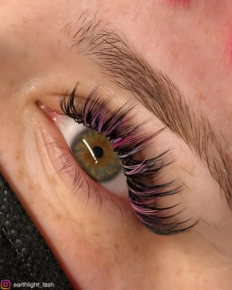 Lash extension set with pink peekaboo color on a green eye