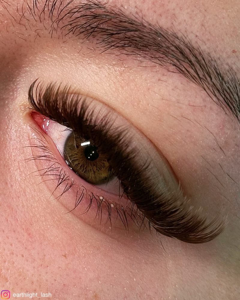 Close up of a full fluffy lash extension set on a hazel eye
