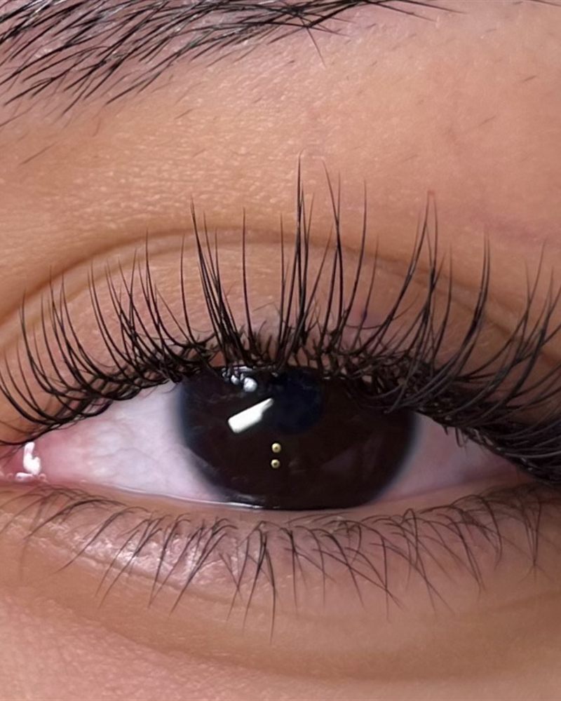 Classic lash extension set, soft and natural close up on a brown eye